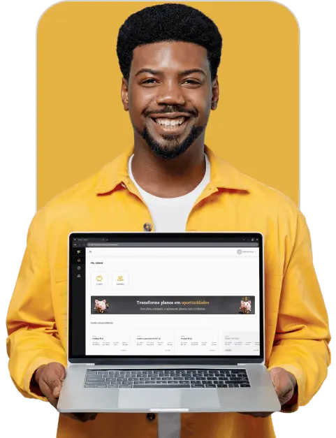 Homem afro descendente com barba curta, usando camisa branca e por cima uma camiseta amarela de botão e manga longa aberta, segurando um notebook mostrando a sua tela, sorrindo.